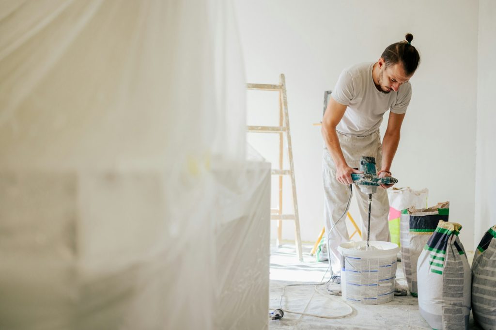 A worker is mixing building materials with manual mixer and renovating.