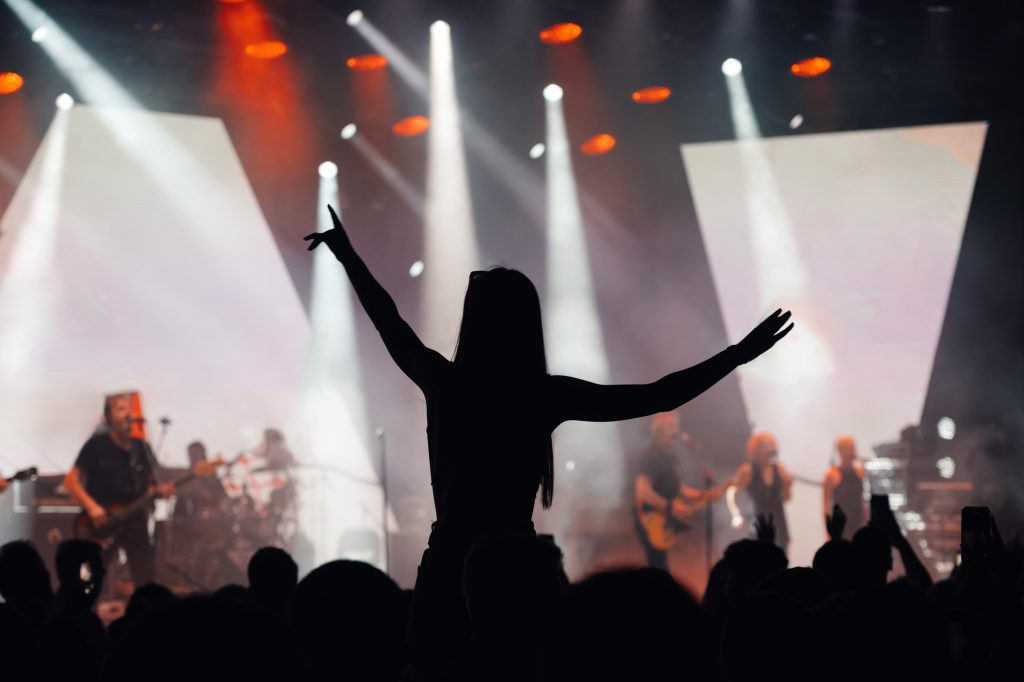 Fan enjoys live music concert with arms spread wide