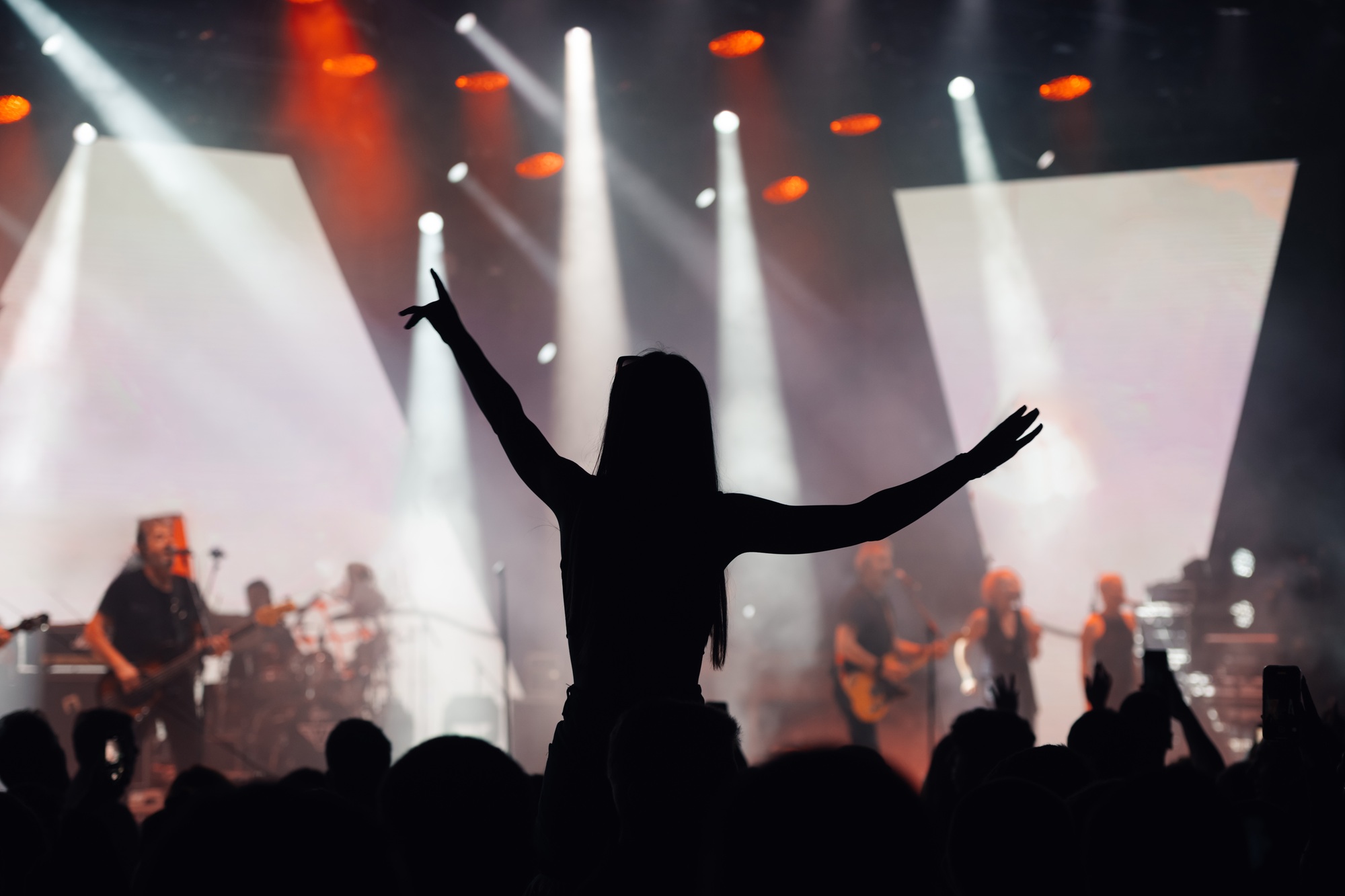 Fan enjoys live music concert with arms spread wide