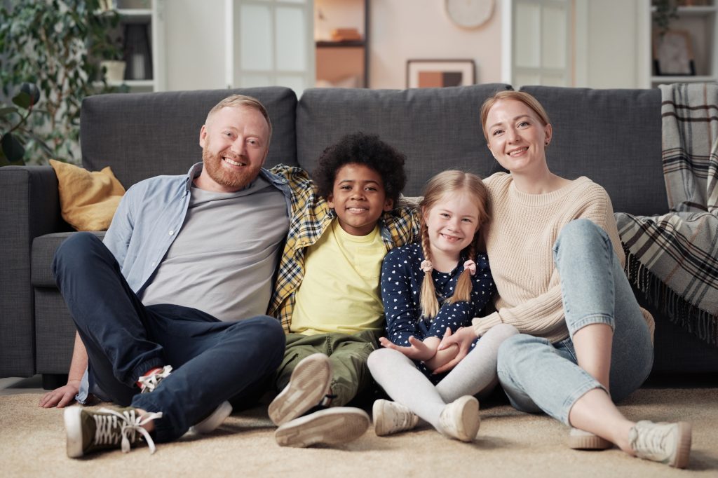 Happy foster family resting at home